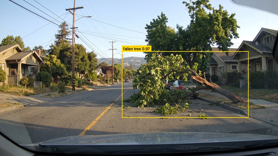 Concept image: a fallen tree limb across a residential street outlined by a yellow detection box